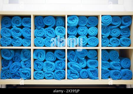 Beaucoup de bouquet bleu vif de serviettes blanches sur les étagères dans le centre de fitness Banque D'Images