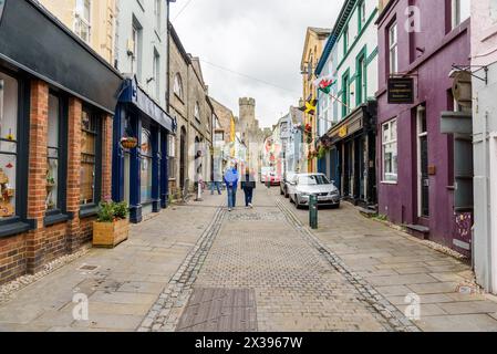 Caernarfon, pays de Galles, Royaume-Uni - 10 juillet 2023 : les gens marchent le long d'une étroite rue pavée dans la vieille ville fortifiée Banque D'Images