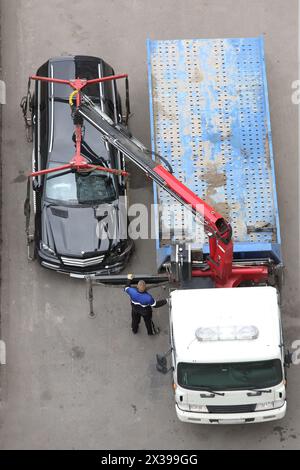 La dépanneuse se fait écraser une voiture noire sur l'autoroute. Banque D'Images