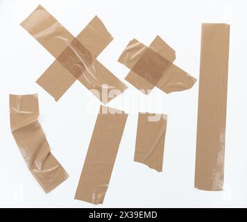 Morceaux de ruban en plastique brun déchiré isolés sur fond blanc de studio Banque D'Images