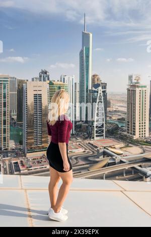 DUBAÏ, Émirats arabes Unis - 13 janvier 2017 : femme sur le toit Looka à Almas Tower, Indigo Tower, palladium, Lake City Tower, Global Lake View, autoroute, chaque année plus th Banque D'Images