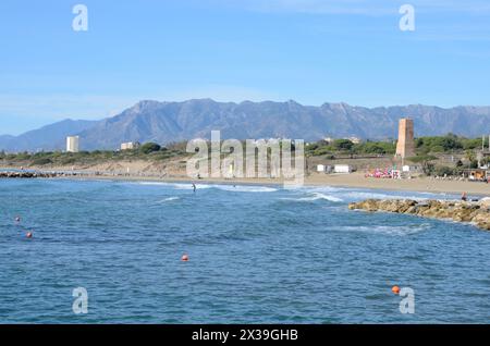 Marbella, Espagne - 8 décembre 2023 : les gens à la plage naturelle avec la montagne en arrière-plan à Marbella, Malaga, Espagne. Banque D'Images