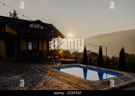 Une maison avec une piscine située en face, mettant en valeur un cadre serein pour la détente et les loisirs. Banque D'Images