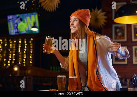 Crier femme fan de football regardant un match de télévision dans un bar sportif Banque D'Images