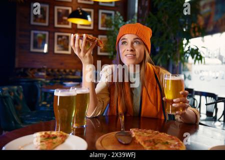 Mignonne femme fan de football regardant le match de télévision dans le bar des sports Banque D'Images