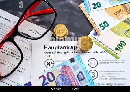 Augsbourg, Bavière, Allemagne - 25 avril 2024 : demande d allocation citoyenne, application principale pour les billets et les pièces en euros. Concept d'assistance sociale *** Antrag auf Bürgergeld, Hauptantrag mit Euro Geldscheinen und Münzen. Sozialhilfe Konzept Banque D'Images