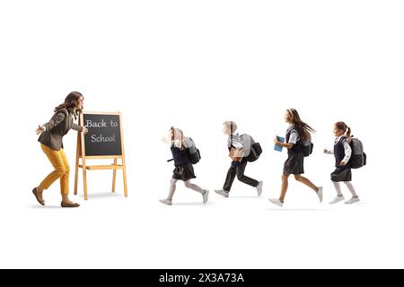 Des écoliers retournant à l'école, courant pour embrasser leur professeur isolé sur fond blanc Banque D'Images