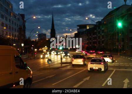 Hambourg, Allemagne - 19 mai 2023 : une rue de la ville la nuit remplie de trafic dense, de voitures, de bus et de piétons se déplaçant précipitamment sous la ville lumineuse Banque D'Images