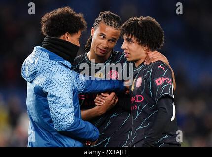 De gauche à droite, Oscar Bobb, Nathan Ake et Rico Lewis de Manchester City célèbrent après le match de premier League à l'American Express Stadium de Brighton. Date de la photo : jeudi 25 avril 2024. Banque D'Images