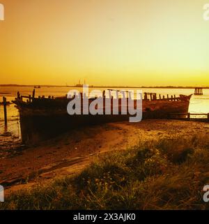 La coque échouée du Hans Egede à Cliffe Fort près de Gravesend Kent, au coucher du soleil, avec la centrale électrique de Tilbury maintenant démolie derrière. Prise vers 19 Banque D'Images