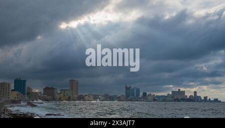 Puits de lumière du soleil brisant à travers les nuages sombres de tempête au-dessus de la Havane Cuba Banque D'Images