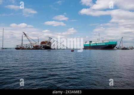 Dundalk (États-Unis d'Amérique). 25 avril 2024. Dundalk (États-Unis d'Amérique). 25 avril 2024. Le porte-véhicules danois Carmen, se déplace à travers un chenal temporaire devant l'épave du Key Bridge effondré alors que le port de Baltimore a été rouvert, le 25 avril 2024, près de Dundalk, Maryland. Le pont a été heurté par le porte-conteneurs de 984 pieds MV Dali le 26 mars et s'est effondré tuant six travailleurs. Crédit : PO2 Ronald Hodges/U.S. Coast Guard/Alamy Live News Banque D'Images
