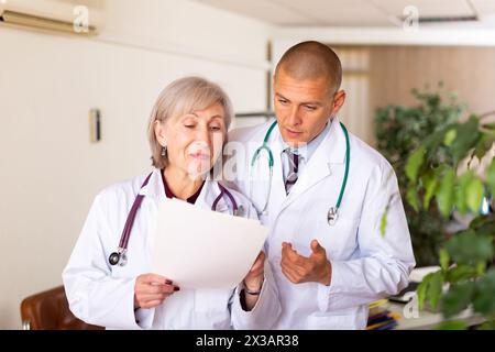 Deux médecins professionnels discutant de la carte médicale du patient Banque D'Images