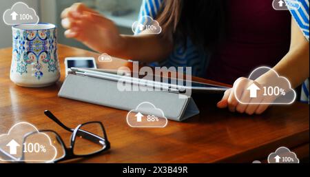 Image de nuages avec un pourcentage allant jusqu'à cent par rapport à une femme utilisant une tablette numérique et un smartphone Banque D'Images