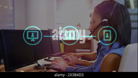 Image d'icônes technologiques sur un groupe multiethnique de personnes travaillant dans un bureau, en utilisant des ordinateurs Banque D'Images