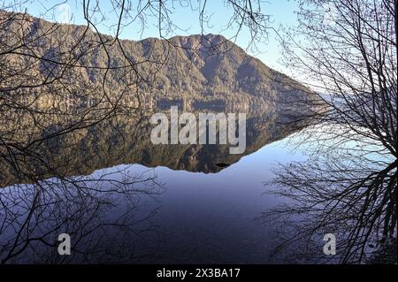 Lake Crescent, près de Port Angeles, WA, montrant un reflet clair de la montagne dans le lac. Naturellement encadré par des branches d'hiver. Banque D'Images