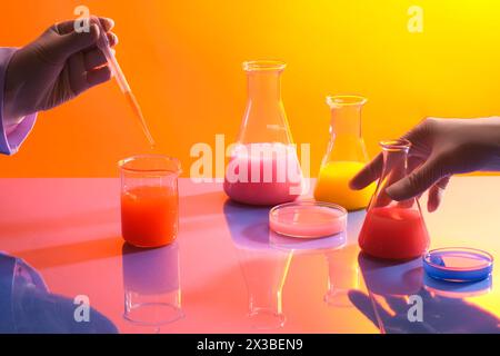 Des flacons coniques et des boîtes de Petri remplies de liquide chimique sont disposés sur la table miroir. Les scientifiques expérimentent avec les outils du technolog moderne Banque D'Images