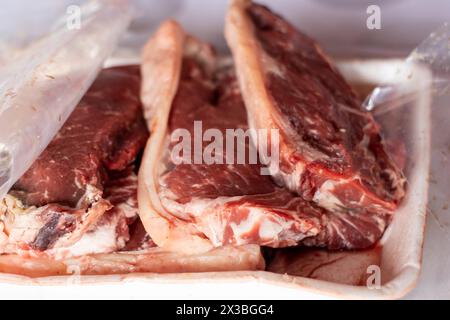 Vue de face de plusieurs morceaux de viande crue côte à côte préparez-vous à cuire sur un grill chaud la journée à l'extérieur Banque D'Images