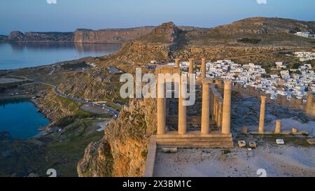 Drone shot, première lumière du matin, Lindos, Acropole de Lindos, Temple d'Athéna Lindia, Acropole avec d'anciennes colonnes devant une mer ensoleillée et Banque D'Images