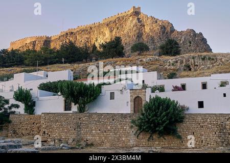 Vue pittoresque d'un château au-dessus d'une ville avec des maisons blanches dans la lumière du soir, Acropole de Lindos, Lindos, Rhodes, Dodécanèse, îles grecques Banque D'Images