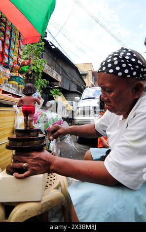 Un artisan travaillant sur une sculpture de Niño de Cebú. Cebu City, Philippines. Banque D'Images