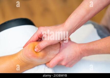 Gros plan des mains d'un massothérapeute professionnel donnant un massage réflexologique des pieds à un patient Banque D'Images