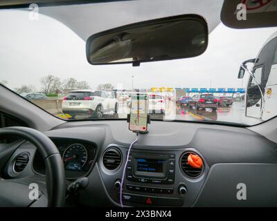 Vue intérieure d'une voiture avec navigation activée, coincée dans la circulation par un jour nuageux, autoroute A1 A8 près de Milan, Italie Banque D'Images