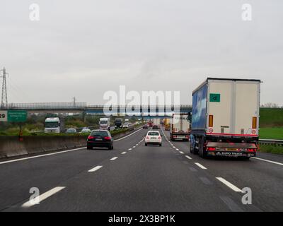 Vue d'une autoroute avec plusieurs voies de circulation et panneaux routiers aériens par temps nuageux, autoroute A1 A8 près de Milan, Italie Banque D'Images