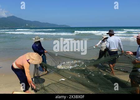 Pêcheurs vietnamiens tirant un grand filet de pêche de la plage de Da Nang, Vietnam. Banque D'Images