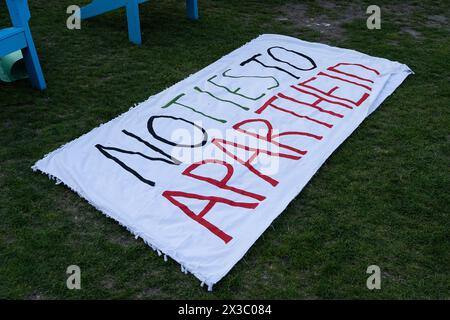 Boston, États-Unis. 25 avril 2024. Un panneau se trouve sur l'herbe à Centennial Common sur le campus de l'Université Northeastern. Les étudiants demandent au gouvernement israélien et aux entreprises de se désinvestir de leur université. Plus tôt dans la journée, la police de Boston en tenue anti-émeute avait encerclé la chaîne étudiante menaçant de fermer leur campement. (Photo de Vincent Ricci/SOPA images/SIPA USA) crédit : SIPA USA/Alamy Live News Banque D'Images