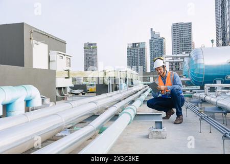 ingénieur technicien masculin travaillant le système de tuyau d'alimentation en eau chaude de réservoir de chaudière d'hôtel de service. homme contrôle la sécurité de l'entretien de l'eau de chauffage de canalisation Banque D'Images