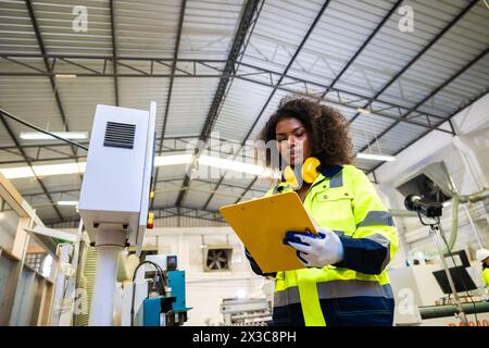 Les femmes noires africaines travaillent avec l'industrie de l'usine de meubles de machine de coupe de bois avec combinaison de sécurité Banque D'Images