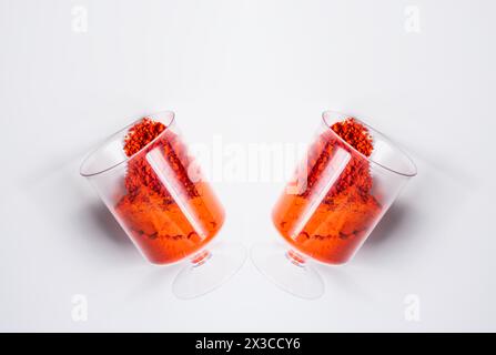 Deux verres de poudre holi rouge sur fond blanc, vue de dessus. Banque D'Images