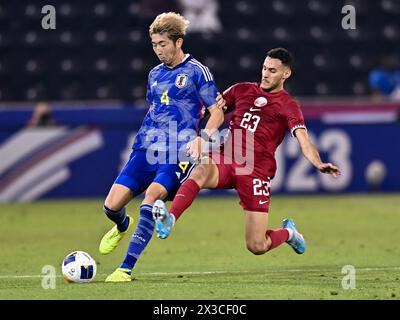 Doha, Qatar. 25 avril 2024. Sekine Hiroki (G), du Japon, affronte Tameem Mansour Alabdulla, du Qatar, lors du match quart de finale entre le Qatar et le Japon lors du tournoi de football AFC U23 Asian Cup Qatar 2024 à Doha, Qatar, le 25 avril 2024. Crédit : Nikku/Xinhua/Alamy Live News Banque D'Images