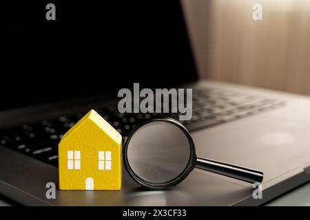 Maison et loupe sur le clavier d'ordinateur portable. Le concept de recherche de logement via Internet. Trouvez un appartement à louer en ligne. Propriété valu Banque D'Images