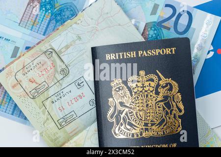 Gros plan sur un nouveau passeport britannique bleu avec des billets en euros en arrière-plan Banque D'Images