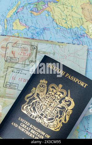 Gros plan sur un nouveau passeport britannique bleu au-dessus de la carte du monde Banque D'Images
