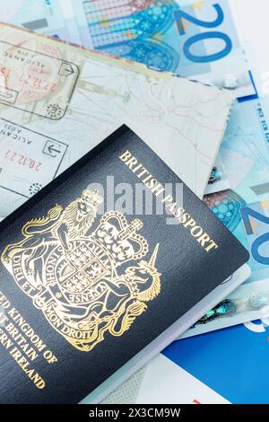 Gros plan sur un nouveau passeport britannique bleu avec des billets en euros en arrière-plan Banque D'Images