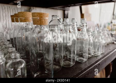 Une rangée soignée de bouteilles en verre transparent avec des bouchons en liège. Banque D'Images
