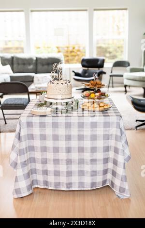 Mise en place de gâteau de douche de bébé et de table de dessert dans une maison élégante Banque D'Images