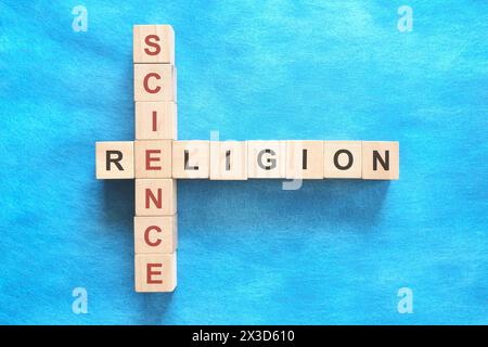 Science et religion relation et concept d'interconnexion. Mots croisés puzzle plat sur fond bleu. Banque D'Images