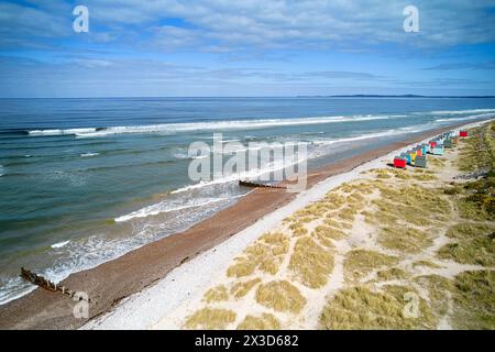 Findhorn Moray Coast Scotland le firth avec un ciel bleu et la mer au printemps cabanes de plage colorées sur la plage de sable et de galets Banque D'Images