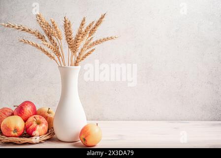 Bouquet de cultures de blé et pommes mûres sur table blanche, espace de copie. Joyeux Shavuot. Maquette de concept shavuot de vacances juives. Banque D'Images