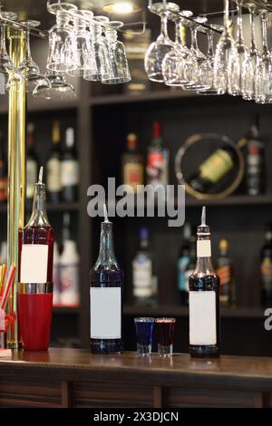 Bouteilles de sirop pour faire coctail sur le comptoir du bar dans la boîte de nuit Banque D'Images