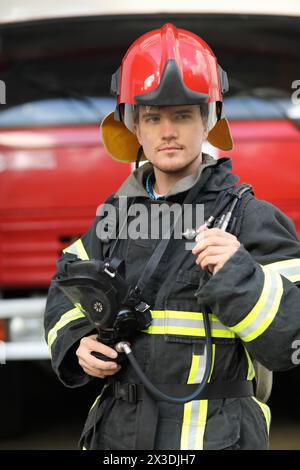 Portrait d'un pompier portant des aiguillages de Fire Fighter et un casque rouge. Banque D'Images