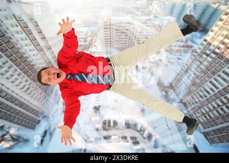 Collage avec homme d'affaires tombant en chemise rouge contre arrière-cour de grands bâtiments, au-dessus de la vue Banque D'Images
