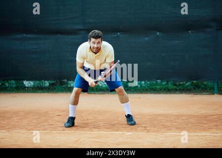 Joueur de tennis attend pour servir à la ligne arrière. Banque D'Images