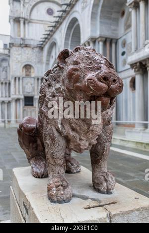 Statue de lion à Piazzetta dei Leoncini - place des petits Lions à côté du côté nord de la basilique St Marc à Venise, Italie. Sculpture en marbre rouge b Banque D'Images