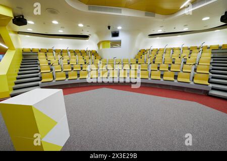 Intérieur de la salle de conférence avec chaises jaunes et microphones, stand pour haut-parleur. Banque D'Images