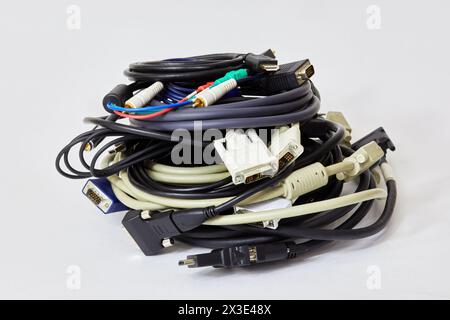 Pile de câbles informatiques enroulés sur fond blanc. Banque D'Images
